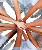 Volunteers joining hands together in teamwork at The Blue Ribbon Project